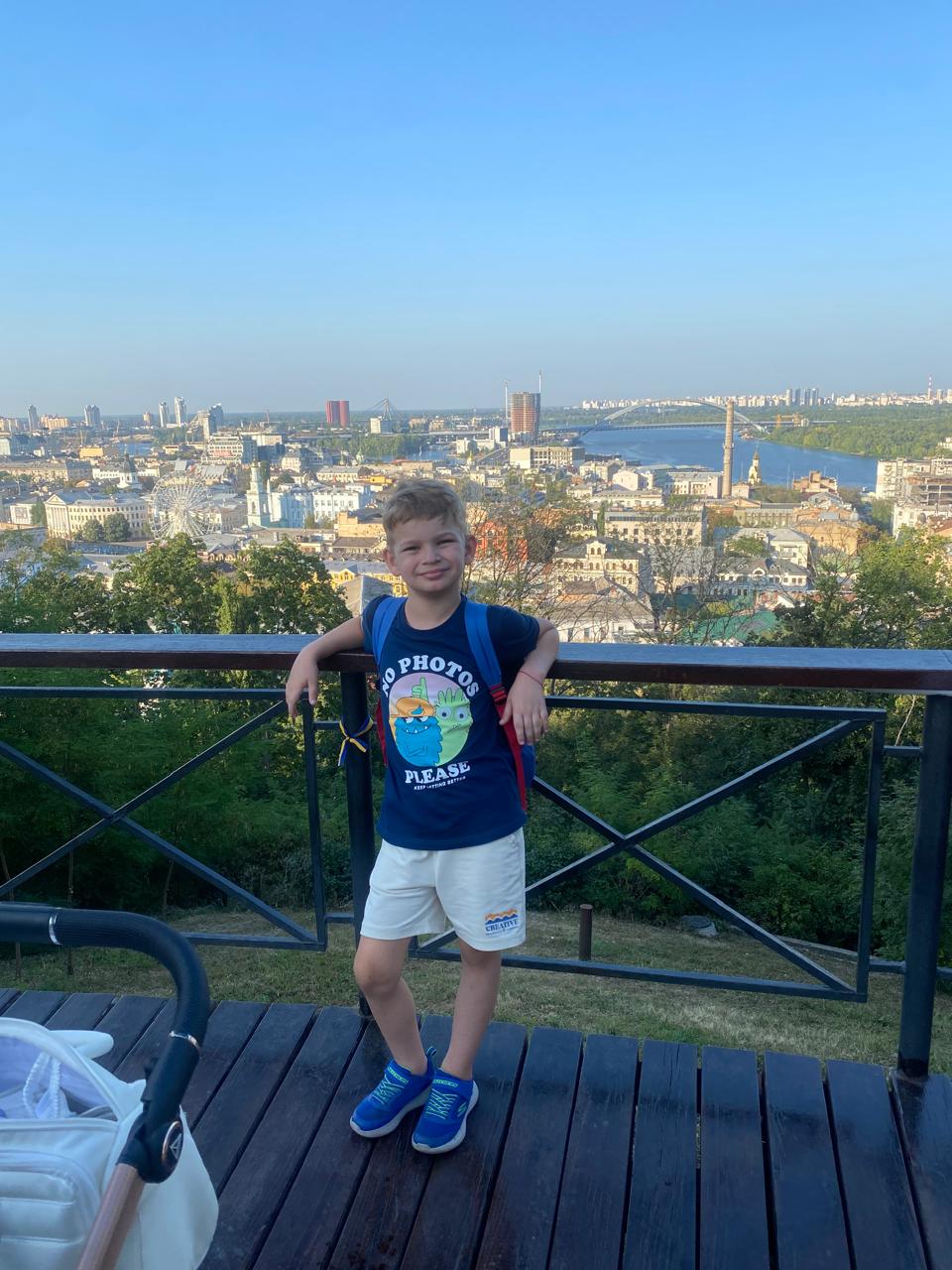 Savva standing at a scenic overlook above Kyiv